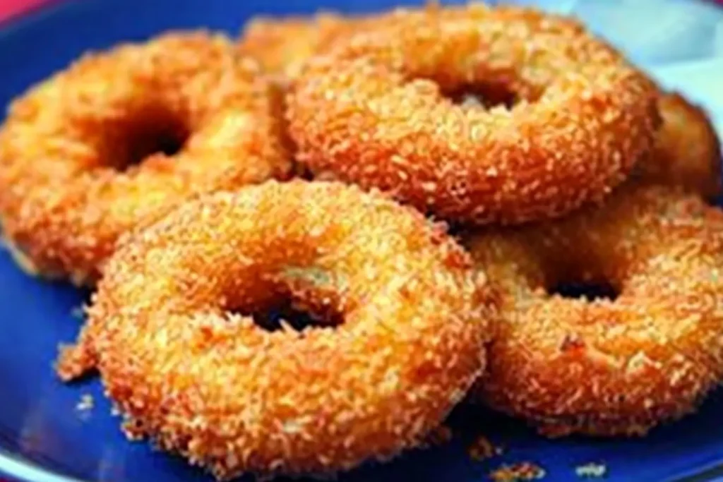 Golden, Crispy Chicken and Potato Doughnuts stacked on a blue plate, showcasing a textured, breadcrumb-coated exterior.